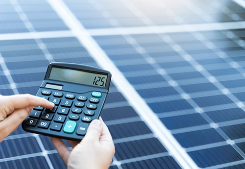 Calculette sur un fond de panneaux photovoltaïques